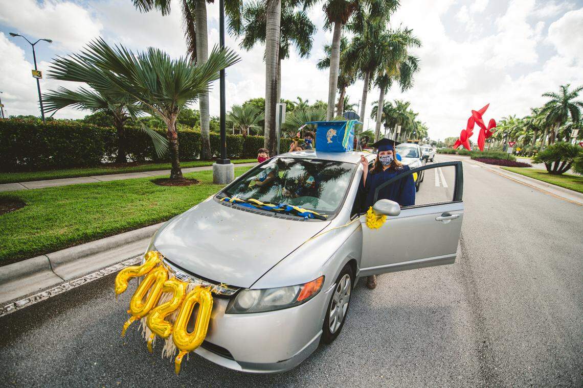Students drive by a pre-commencement caravan at Florida International University in 2020. They were able to stop by at a specific point on campus before the ceremony to purchase graduation gear, a class ring and take a portrait.