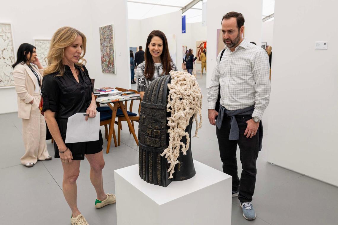 Guests look over ‘Untitled’ by Roberto Diago while on a private tour hosted by Toma Wolff at Untitled Art Fair for Art Week on Tuesday, Dec. 3, 2024, in Miami Beach, Fla