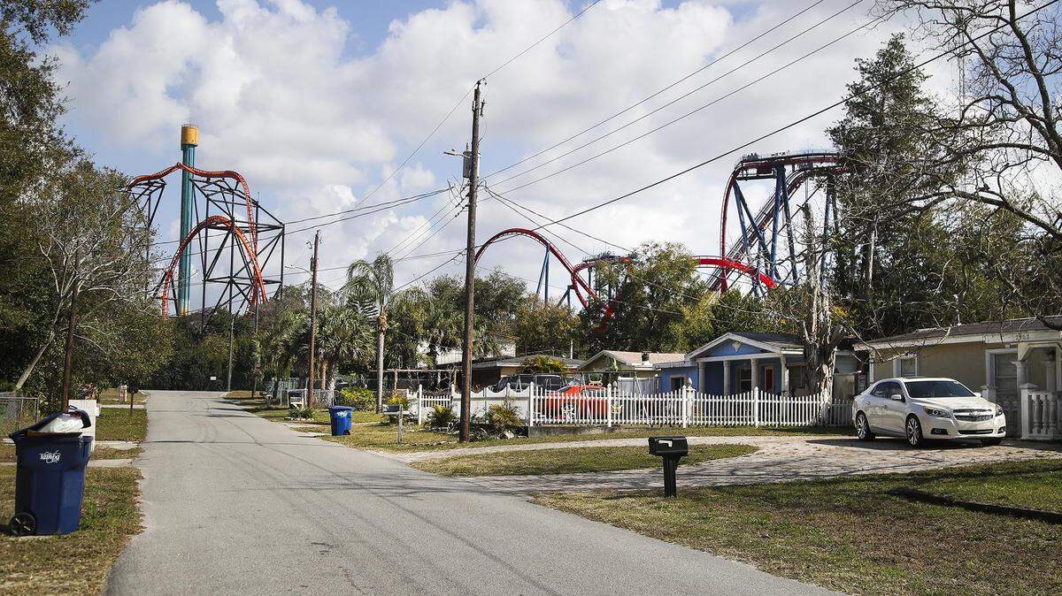 A view of the street with roller coasters at Busch Gardens visible in the background in a Tampa neighborhood where many rental homes are owned by a real estate investment fund whose top foreign investors are heirs of the French fashion company Hermès.