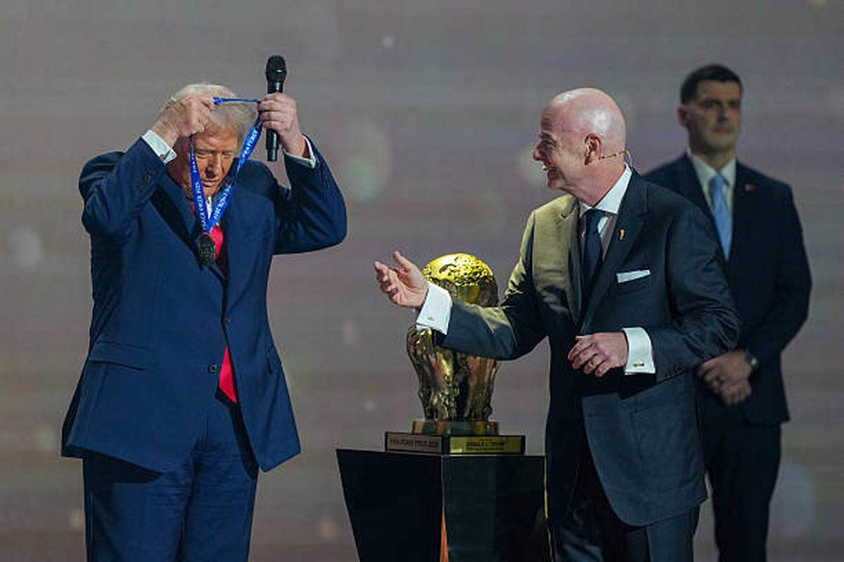 US President Donald Trump puts on a medal as he receives the FIFA Peace Prize from FIFA President Gianni Infantino during the draw for the 2026 FIFA Football World Cup taking place in the US, Canada and Mexico, at the Kennedy Center, in Washington, DC, on December 5, 2025. (Photo by Stephanie Scarbrough / POOL / AFP via Getty Images)