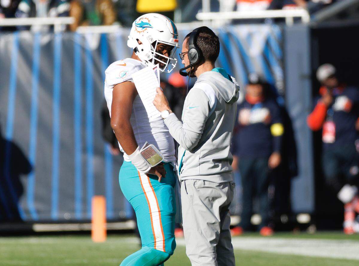 Miami Dolphins head coach Mike McDaniel talks with Dolphins quarterback Tua Tagovailoa (1) during third quarter of an NFL football game against the Chicago Bears at Soldier Field on Sunday, November 6, 2022 in Chicago, Illinois.