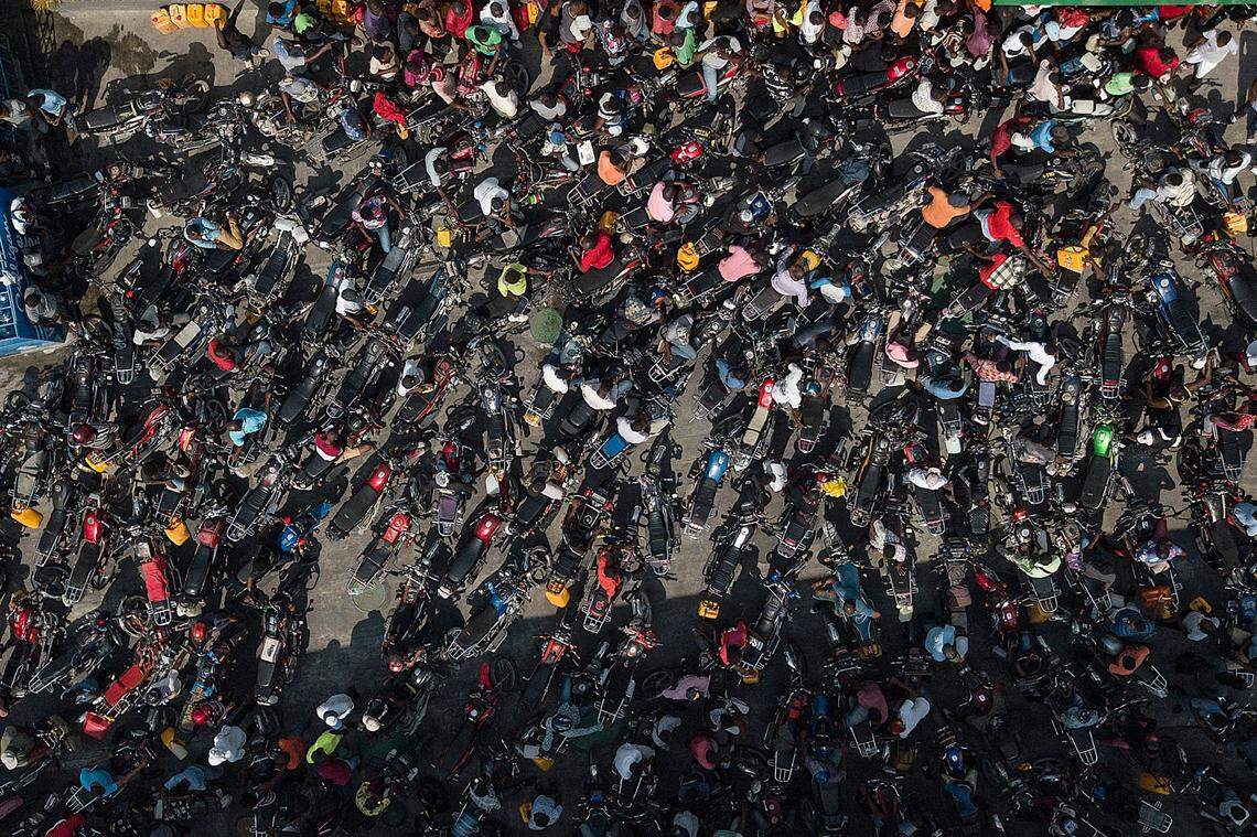 People gather at a gas station in hopes of filling their motorcycles in Port-au-Prince, Haiti, Sunday, Oct. 31, 2021, during a national fuel shortage.