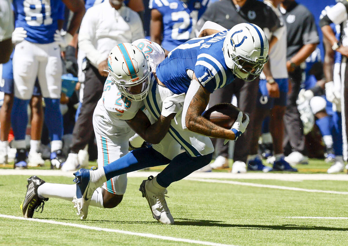 Indianapolis Colts wide receiver Michael Pittman Jr. (11) is brought down by Miami Dolphins cornerback Rasul Douglas (26) during the first half of an NFL game at Lucas Oil Stadium on Sunday, Sept. 7, 2025, in Indianapolis, Indiana.