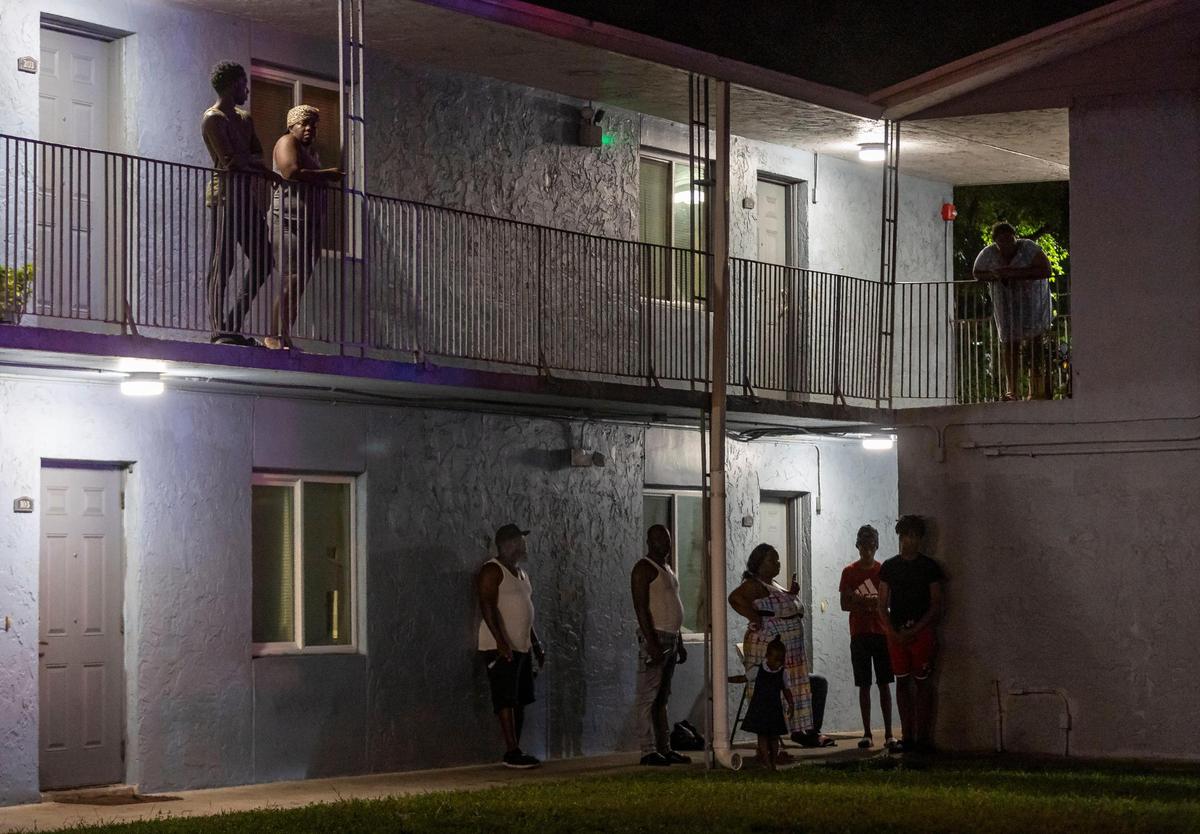 Residents watch as police work a crime scene near the 2900 block of NW 19th Street on Wednesday, July 5, 2023, in Fort Lauderdale, Fla. Police say five people were transported to the hospital after an altercation between two groups of people ended in gunshots.