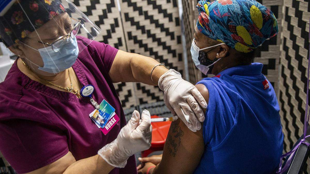Nurse Lynnette Lee vaccinates Miami Jewish Health employee Crystal McCutcheon with the Moderna vaccine on Thursday, Aug. 19, 2021.