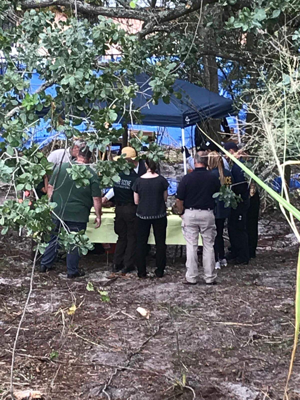 Investigators examine remains found in a small wooded area in Miami Gardens, Florida, on Thursday, Dec. 13, 2018.