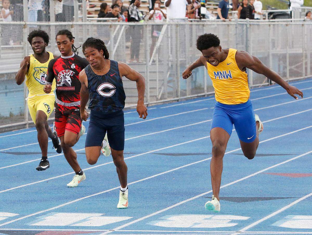 Northwestern’s Jamari Sharpe (right) wins boys 100 meter dash during the GMAC Track and Field Championship on Thursday, April 7, 2022 at Traz Powell Stadium in Miami. Andrew Uloza / for THE MIAMI HERALD