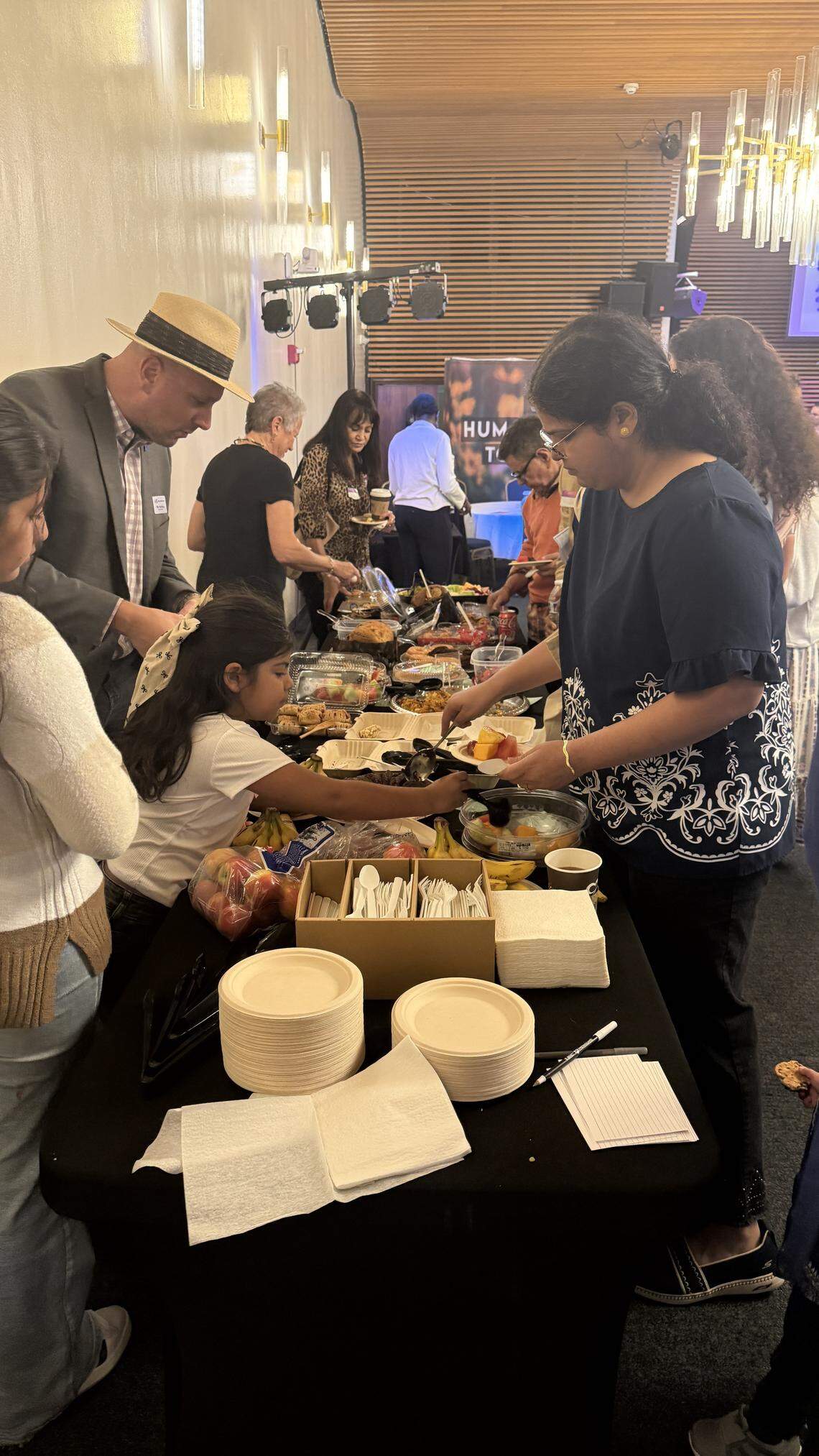 People gather to fill their plates at an interfaith potluck at Unity on the Bay. The event at Temple Israel of Greater Miami offered a sampling of religious traditions and reflections from a host of local faith leaders.