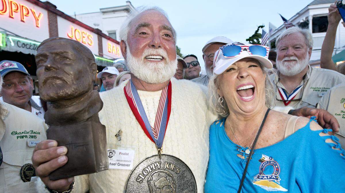 Michael Groover, left, husband of celebrity chef Paula Deen, right, answers a journalist's question after winning the Hemingway Look-Alike Contest on Saturday, July 21, 2018, at Sloppy Joe's Bar in Key West.