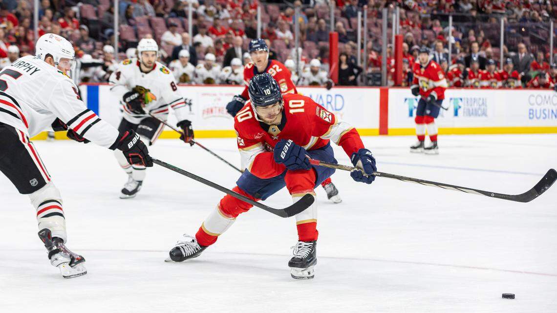 Florida Panthers left wing A.J. Greer (10) skates with the puck as Chicago Blackhawks defenseman Connor Murphy (5) defends in the third period of their NHL game at Amerant Bank Arena on Saturday, Feb. 1, 2025, in Sunrise, Fla.