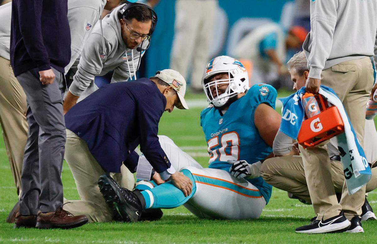 Miami Dolphins guard Connor Williams (58) is treated after being treated during the game against the Tennessee Titans in the first half at Hard Rock Stadium in Miami Gardens, Florida on Monday, December 11, 2023.