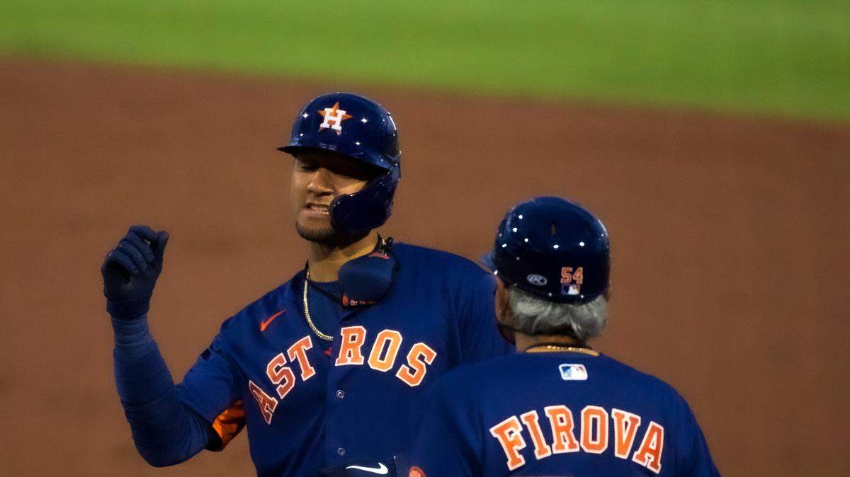 Houston Astros first baseman Yuli Gurriel (10) is congratulated by Astros coach Dan Firova (54) after hitting a single during the second inning of the spring training baseball game at Roger Dean Chevrolet Stadium on Wednesday, March 10, 2021 in Jupiter, Florida.