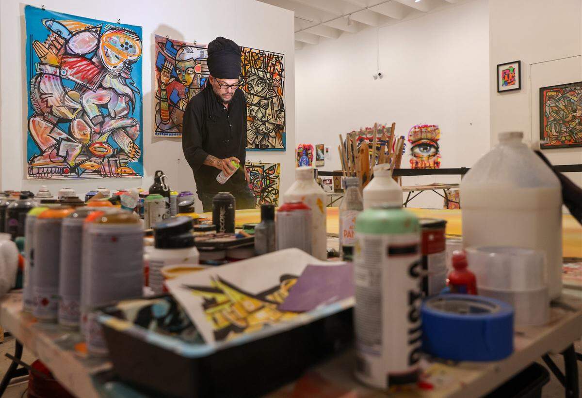 James “Ras Terms” Monk sprays paint while working on a new piece at The Museum of Graffiti Artist Studios in Wynwood, Miami, Tuesday, April 7, 2026.  A Miami native, Monk began painting at age 11 and left the city in 2000 to work and live across the U.S. and Latin America. Now, he returns to Wynwood with a new process he describes as 'Ancient Futurism,' reflecting his artistic evolution.
