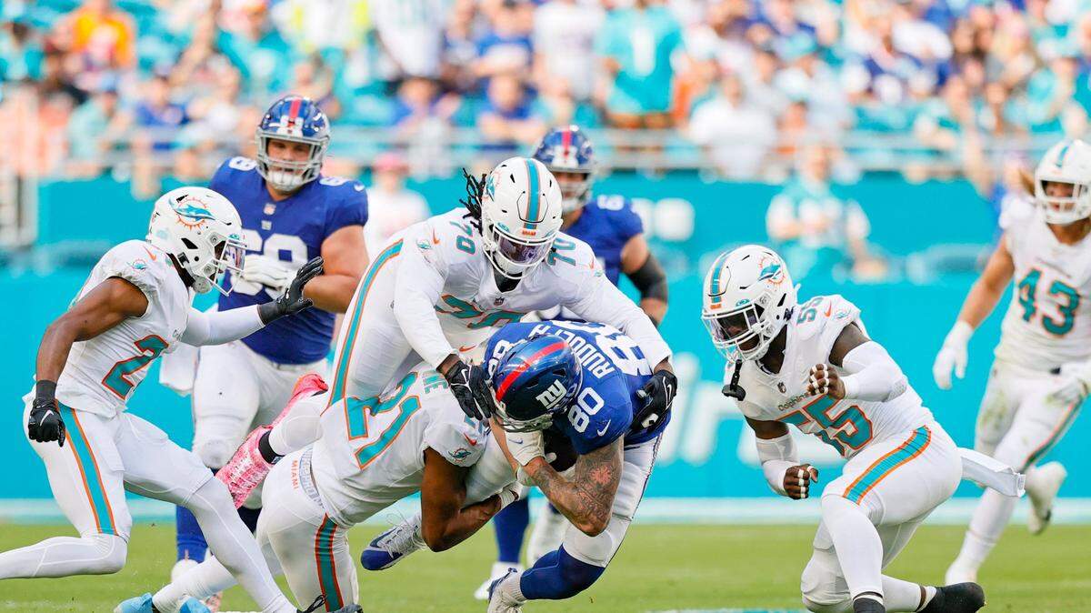 Miami Dolphins players Byron Jones (24) Adam Butler (70) Eric Rowe (21) and Jerome Baker (55) bring down New York Giants tight end Kyle Rudolph (80) during the first quarter of an NFL football game at Hard Rock Stadium on Sunday, December 5, 2021 in Miami Gardens, Florida. (David Santiago Photo / Miami Herald)