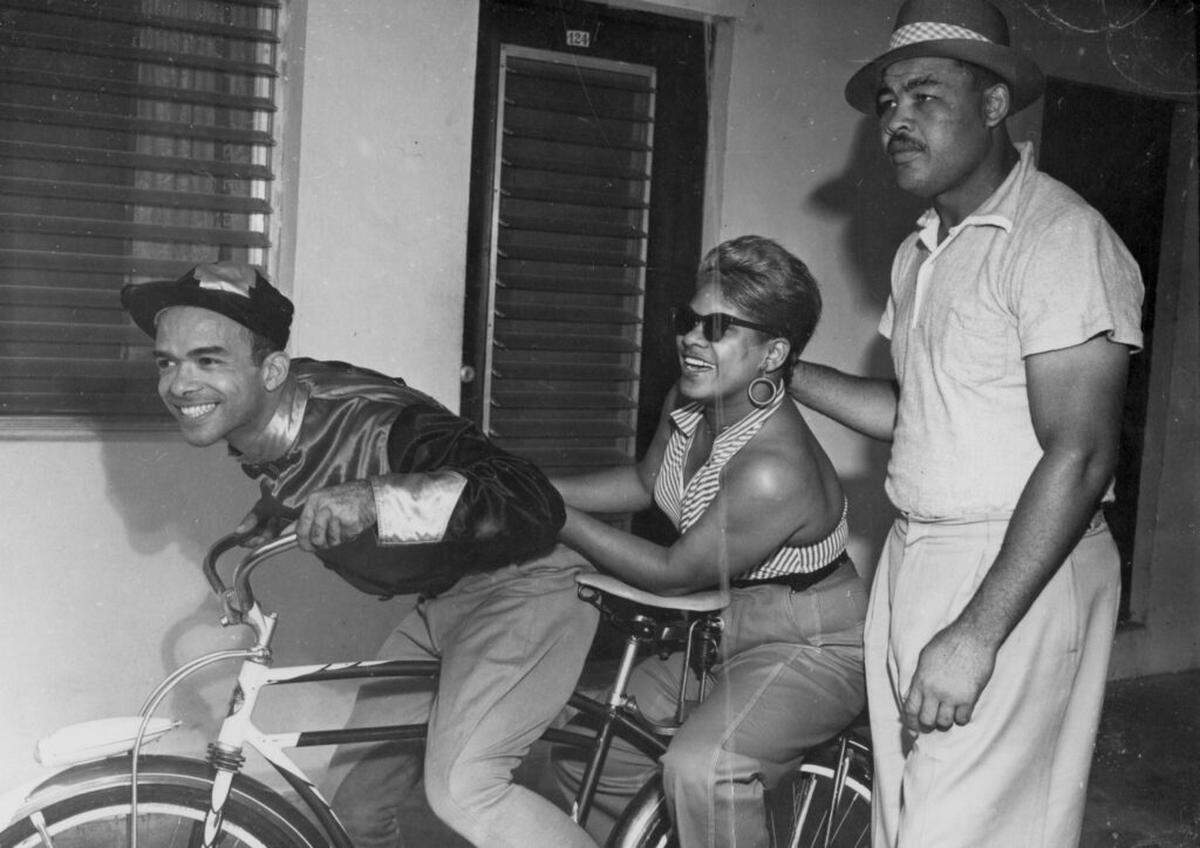 DJ ‘Jockey Jack’ Gibson, left, poses for a promotional picture in his WFEC jockey attire on a bicycle with R&B singer Ruth Brown, center, and boxing champion Joe Louis at the Lord Calvert Hotel (circa. 1953). Indiana University Archives of African American Music and Culture, SC 14 Jack Gibson Collection.
