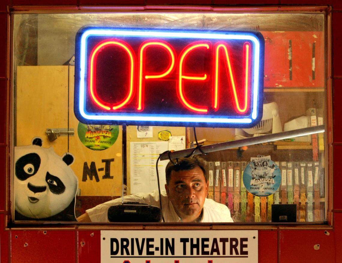 Operations manager Stuart Addison looks out the ticket booth window at the Swap Shop Thunderbird Drive-In Theater in 2009.
