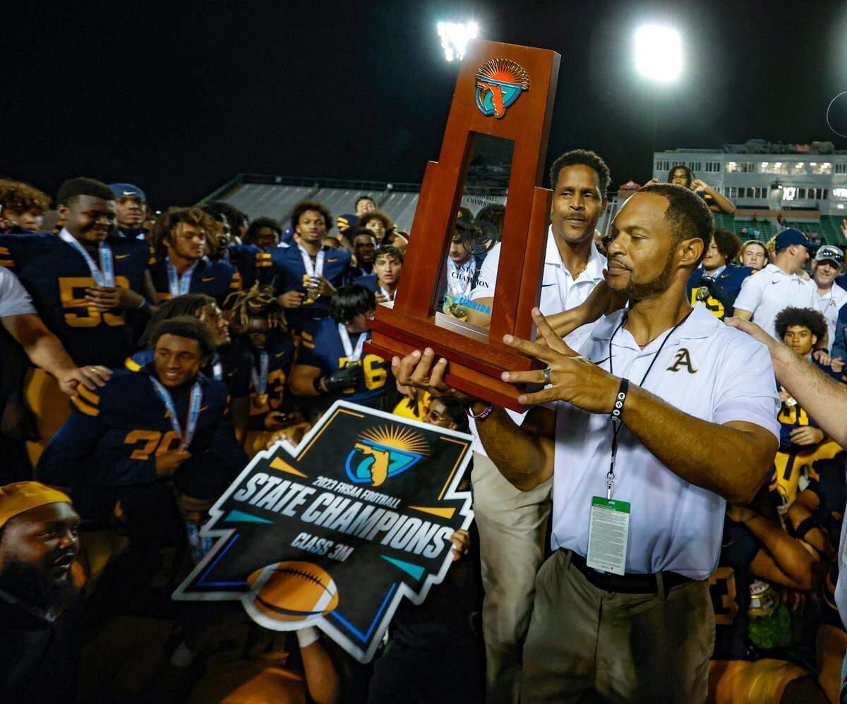 St. Thomas Aquinas coach Roger Harriott holds the state championship trophy after defeating the Homestead Broncos in the Class 3M state championships at Bragg Memorial Stadium in Tallahassee, Florida on Saturday, December 9, 2023.