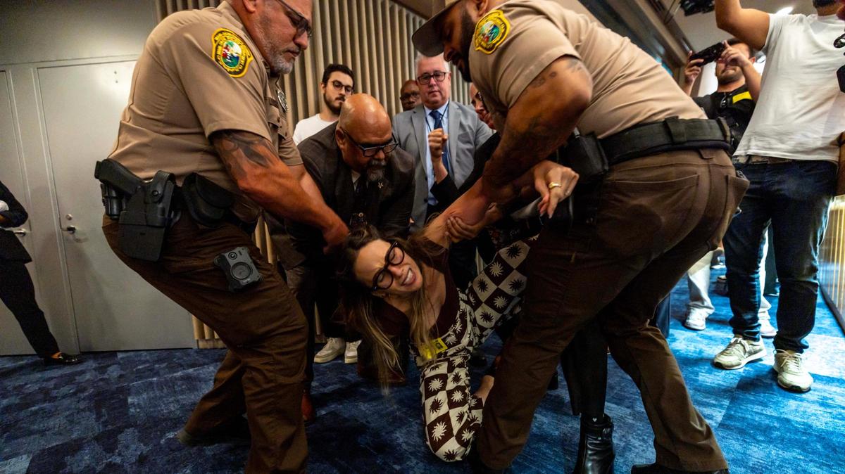Camila Ramos is forcibly removed from the commission chambers by officers during a Miami-Dade County Commission meeting at the Stephen Clark Center on Thursday, June 26, 2025, in Miami, Fla.