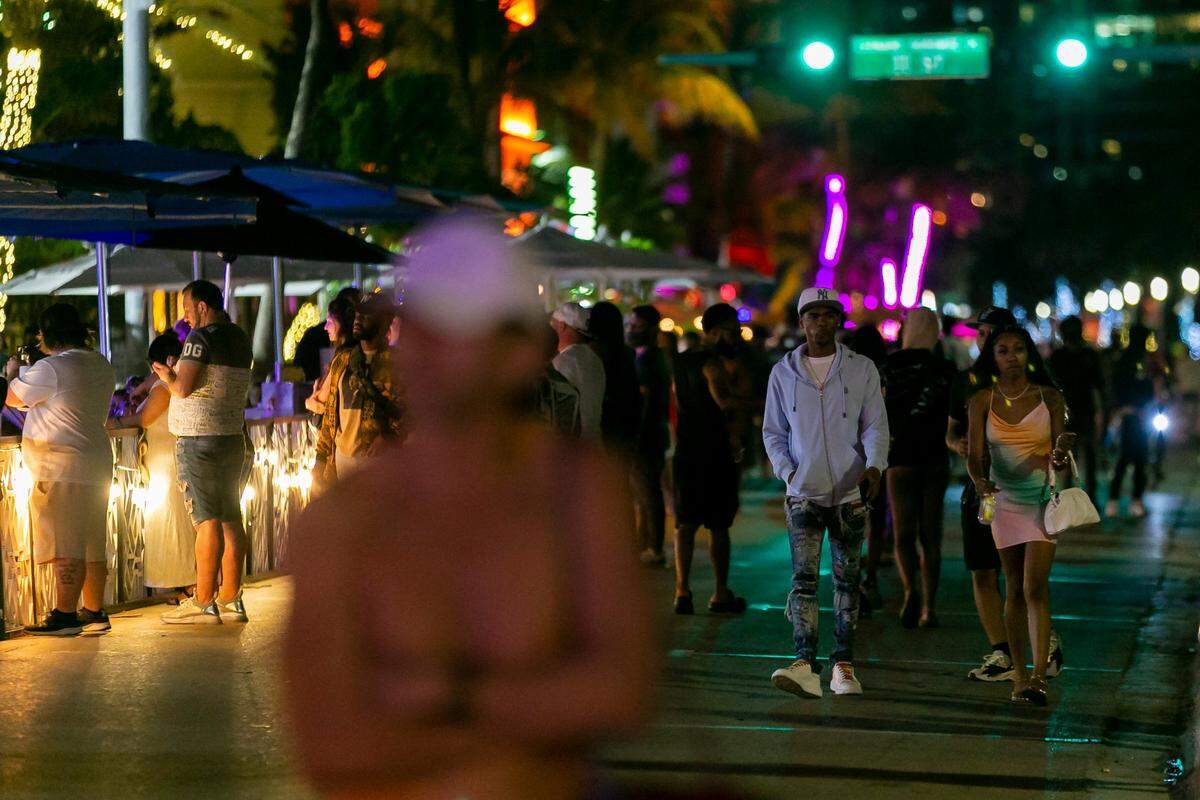 Tourists walk along Ocean Drive during Spring Break in Miami Beach, Florida, on Monday, March 22, 2021. Miami Beach had planned official activities for visitors on the beach, but canceled those plans, citing COVID-19 risks.