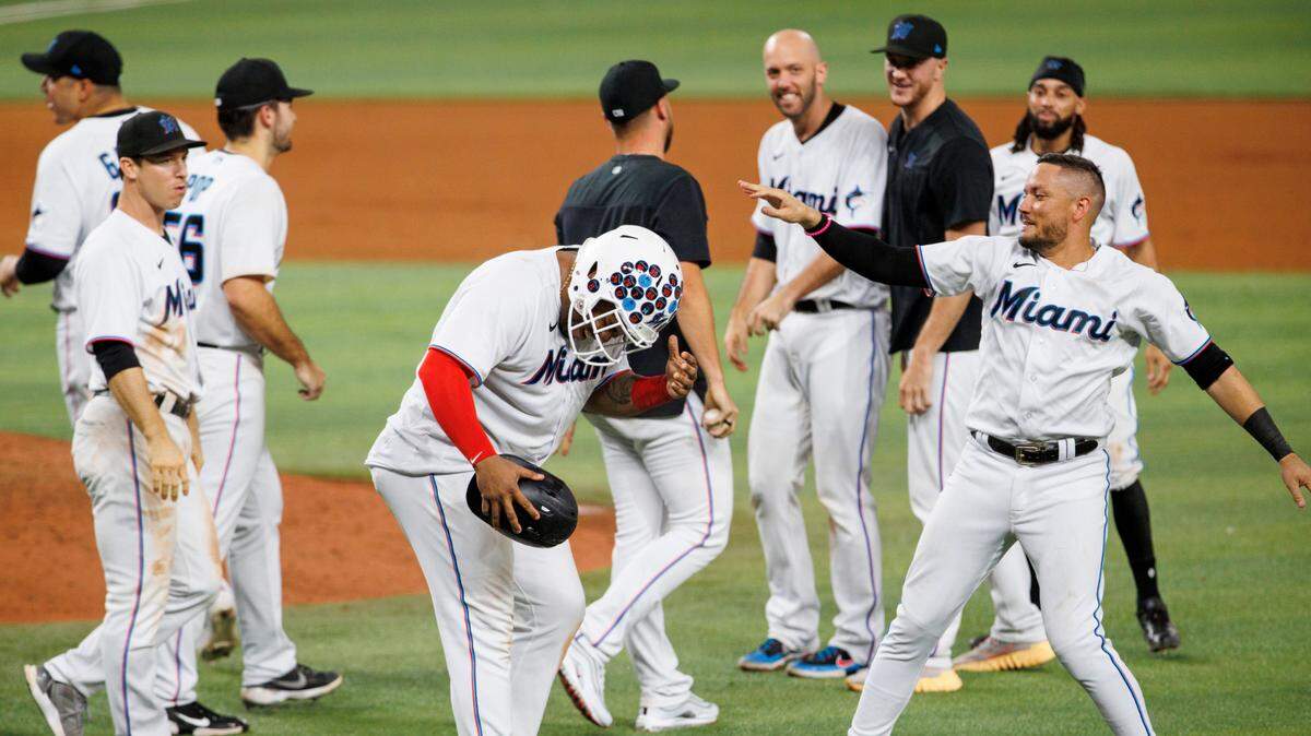 Miami Marlins first baseman Jesus Aguilar (99) celebrates with teammate Miguel Rojas (11) after scoring on a wild pitch for a walk-off 5-4 win over the Pirates during the tenth inning of a baseball game at LoanDepot Park on Wednesday, July 13, 2022 in Miami, Florida.