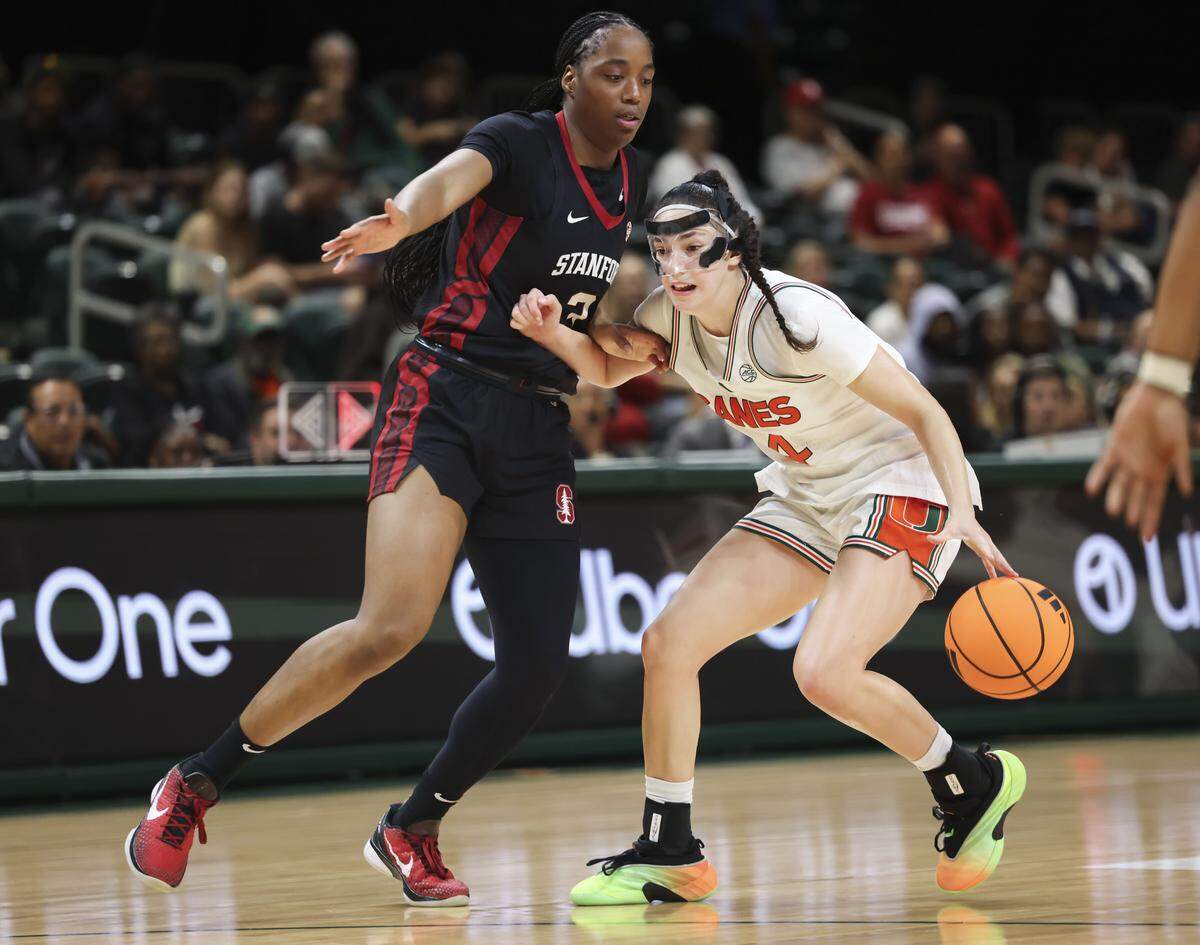Miami Hurricanes guard Gal Raviv (14) dribbles around Stanford Cardinal forward Nunu Agara (3) during the second half of a game on Thursday, Feb. 19, 2026, at Watsco Center in Coral Gables, Fla.
