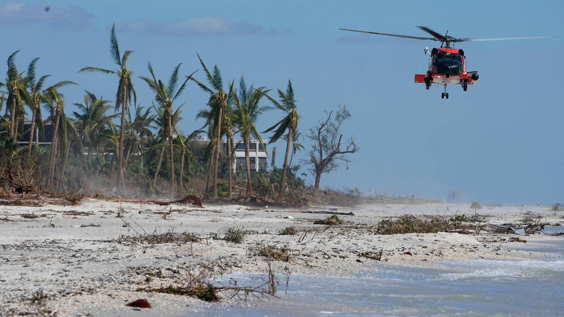 A U.S. Coast Guard helicopter prepares to land on the beach to ferry people off the island, in the wake of Hurricane Ian, Friday, Sept. 30, 2022, on Sanibel Island, Fla. (AP Photo/Steve Helber)