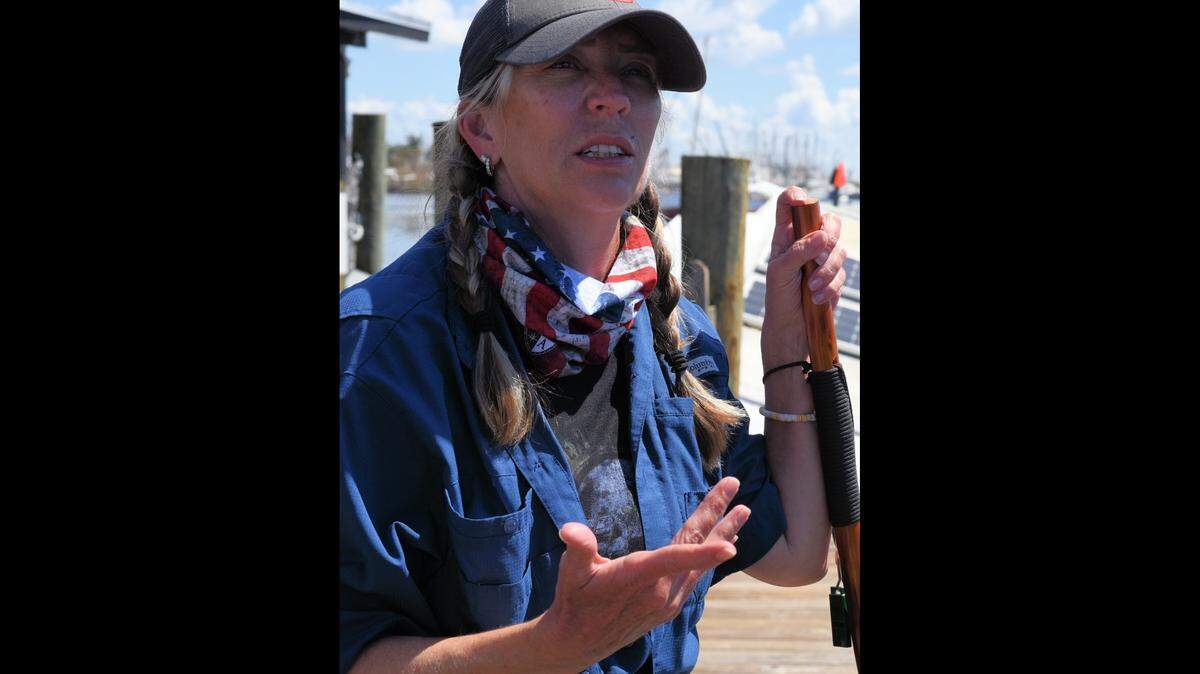 Crystal Edge, 53, of Naples, Florida, pauses on a damaged pier Saturday, Oct. 1, 2022, to discuss salvage efforts on her family’s 28-foot sailboat, which was destroyed by Hurricane Ian at a marina near Fort Myers Beach.