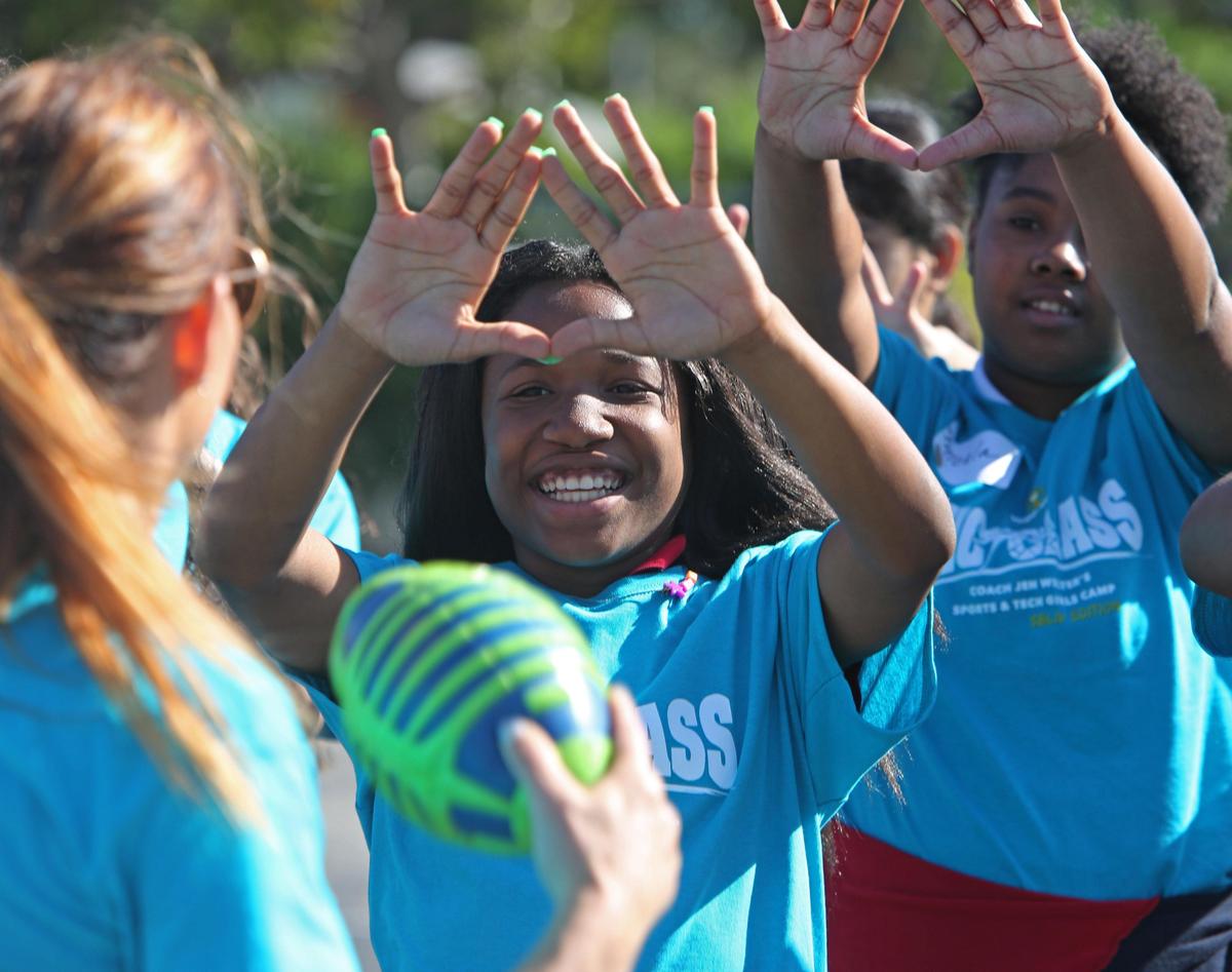 Brianna Pollard, 12, has her hands up and ready to catch a pass from Dr. Jen Welter as Welter ran the girls through football drills at Jose De Diego Middle School, Thursday, January 30, 2020. Welter, the first female to coach in the NFL, was coaching the KickGlass Sports Meets Tech Camp, a program designed to introduce football and technology to young girls.