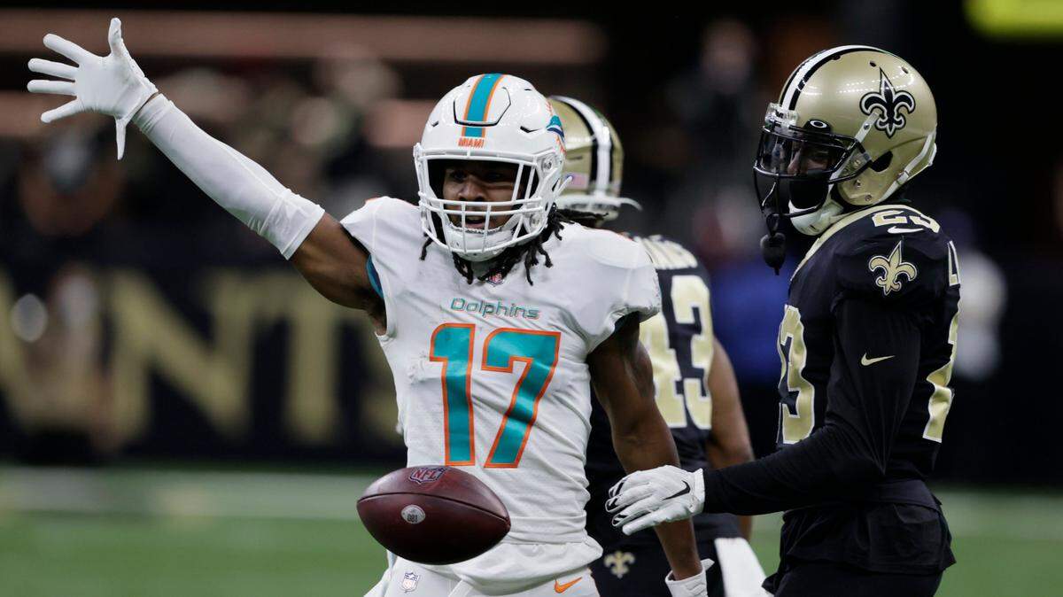 Miami Dolphins wide receiver Jaylen Waddle (17) drops the ball in front of New Orleans Saints cornerback Marshon Lattimore (23) after making a catch during the first half of an NFL football game Monday, Dec. 27, 2021, in New Orleans. (AP Photo/Butch Dill)