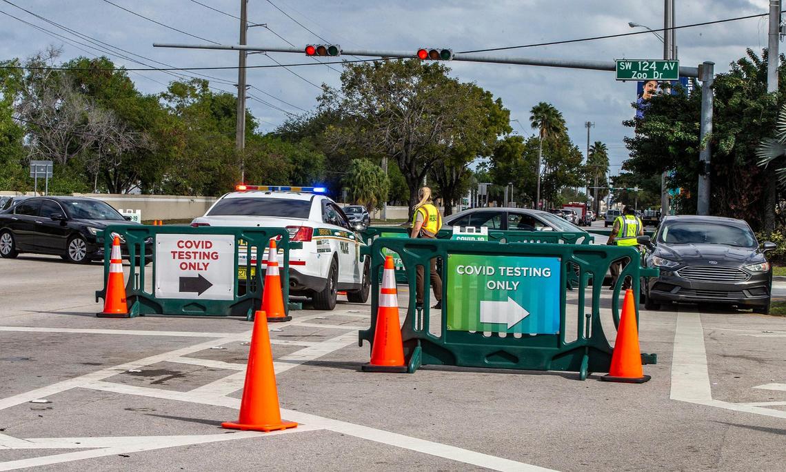 Miami-Dade Police officers control a moderate line of cars at Zoo Miami to get the COVID-19 test on Tuesday afternoon, January 04, 2021.