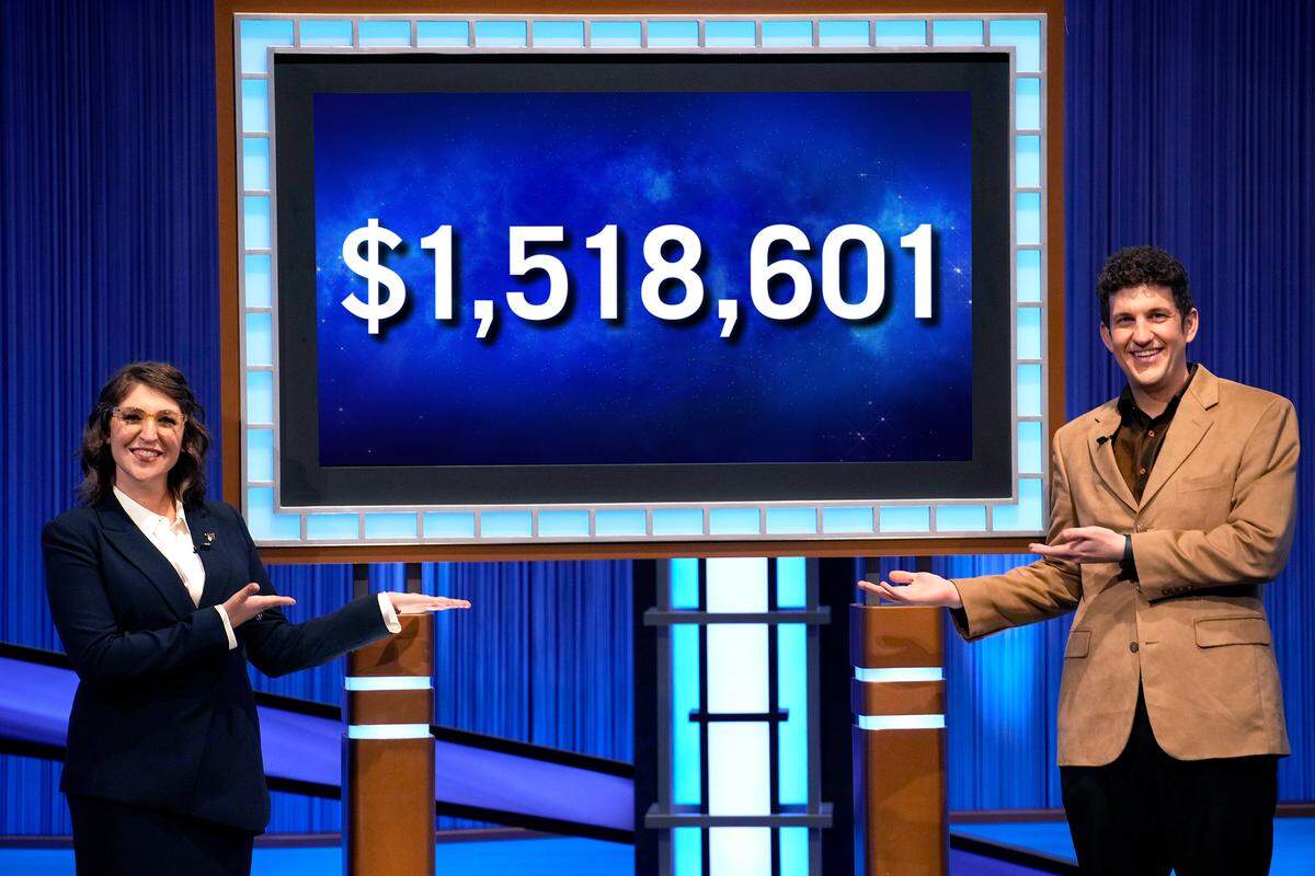 ‘Jeopardy!” host Mayim Bialik and 38-game champ Matt Amodio pose with his earnings, more than $1.5 million, on the episode that aired Oct. 11, 2021.