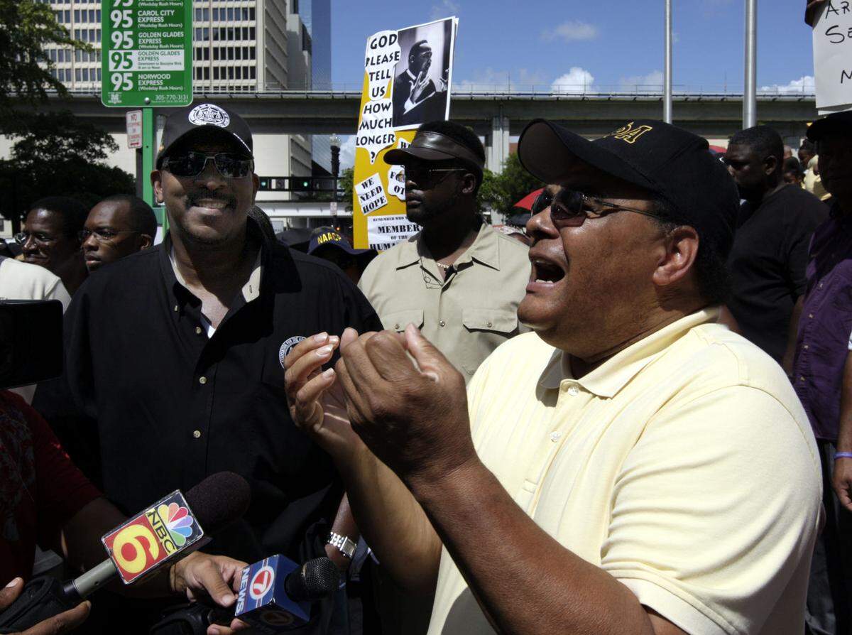 Timmy Thomas, right, sings his 1972 classic, “Why Can’t We Live Together,” as Bishop Victor T. Curry, left, watches on Aug. 28, 2007, when members of the NAACP, labor unions, and other groups held protest marches from the Dade County Courthouse to the Stephen Clark Government Center to commemorate the 44th anniversary of the 1963 March on Washington.