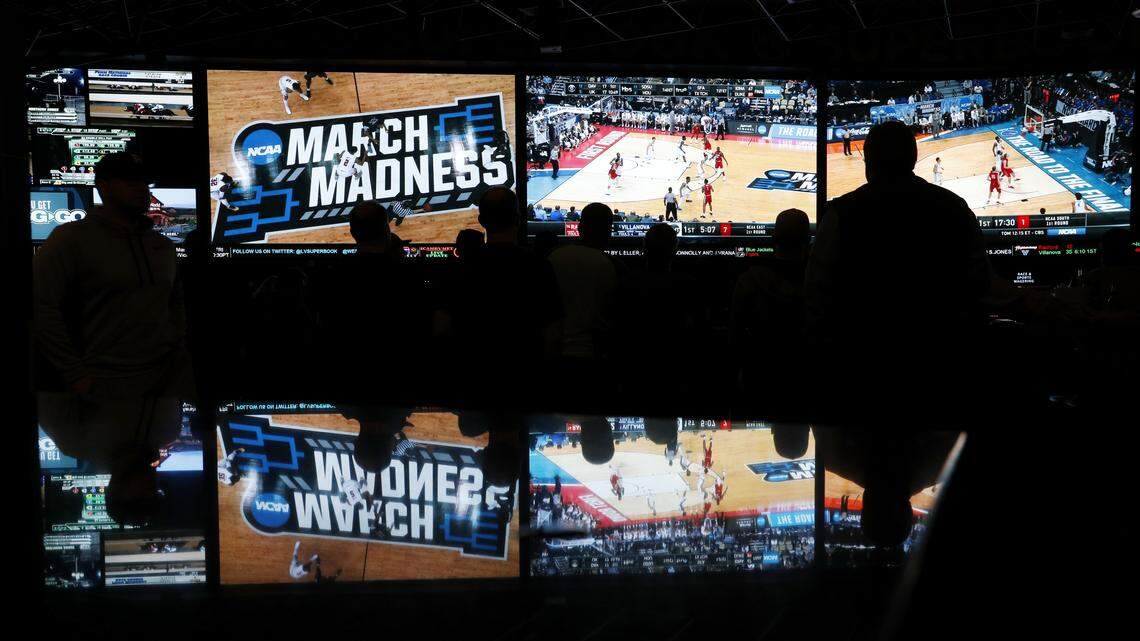 In this March 15, 2018, photo, people watch coverage of the first round of the NCAA college basketball tournament at the Westgate Superbook sports book in Las Vegas. The Supreme Court has struck down a federal law that bars gambling on football, basketball, baseball and other sports in most states, giving states the go-ahead to legalize betting on sports.