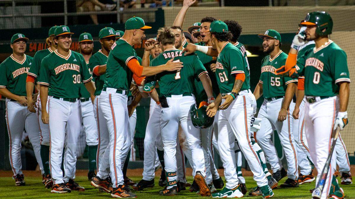 University of Miami players react after Jacob Burke (7) homered during the fifth inning of an NCAA baseball game against Towson University inside Alex Rodriguez Park at Mark Light Field in Coral Gables, Florida, on Friday, February 18, 2022.