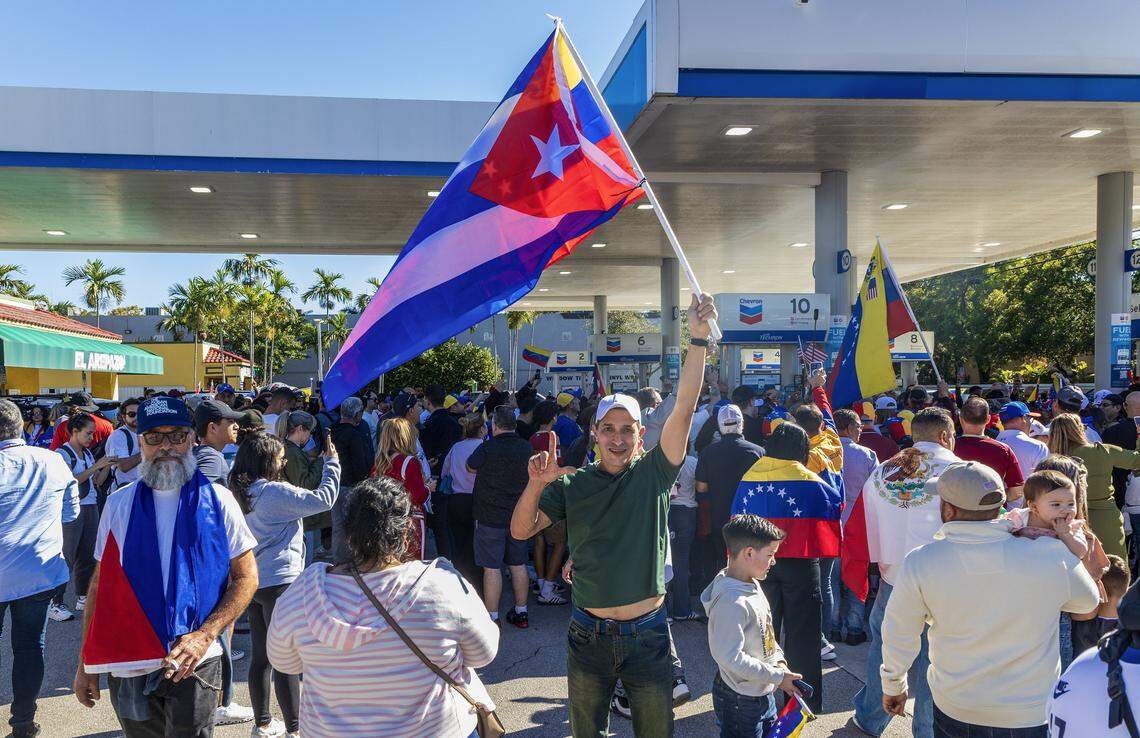 Cuban exiled Michael Berger waves a Cuban and a Venezuelan flags as he joined a group of Venezuelan exiles living in South Florida celebrating outside of El Arepazo in Doral, Florida, after the United States attacked Venezuela and captured Venezuelan leader Nicolás Maduro,  on Jan. 3, 2026.