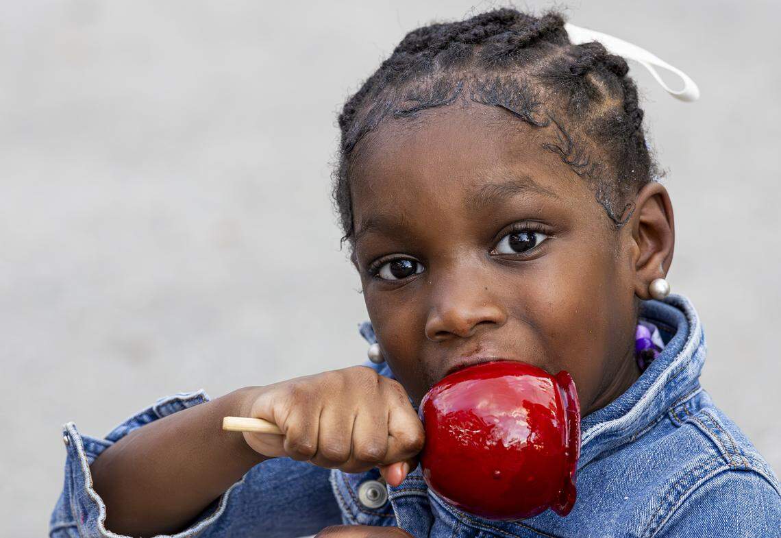 Bailey Williams, 4, bites into a candy apple during the opening day of the 74th annual Miami-Dade County Youth Fair on Thursday, March 12, 2026, in Miami, Fla.