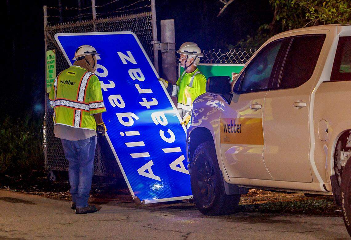 Two workers get ready to cover the Dade-Collier Training and Transition Airport with the “Alligator Alcatraz,” sign at the entrance of the migrant detention center, in Ochopee, Florida on Wednesday July 02, 2025.