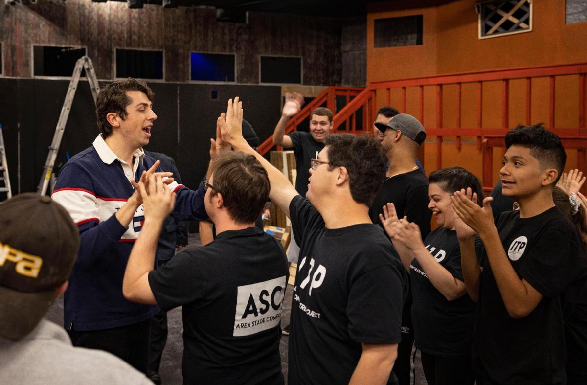 The director Jorge Amador, left, closes rehearsal with high fives from Alexander Milne and Joseph Paz during the Inclusion Theatre Project’s rehearsal for ‘Elf Jr.’ the musical on Monday, Nov. 28, 2022, at Area Stage Company in South Miami. Area Stage’s Inclusion Theatre Project gives children and young adults diagnosed with disabilities the opportunity to experience and perform in theatre.