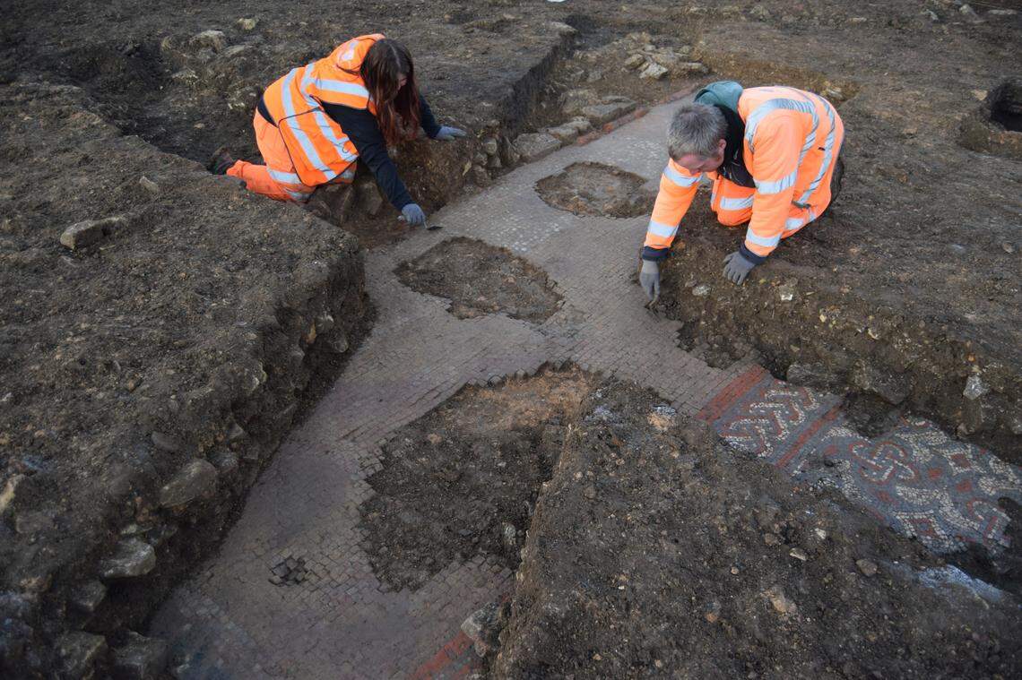 Archaeologists cleaning the edge of the mosaic.