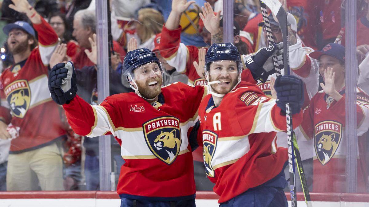 Florida Panthers center Sam Bennett (9) and left wing Matthew Tkachuk (19) celebrate after defenseman Niko Mikkola (77) scored against Carolina Hurricanes goaltender Pyotr Kochetkov (52) in the third period of Game 3 during the Eastern Conference final of the NHL Stanley Cup playoffs at Amerant Bank Arena on Saturday, May 24, 2025, in Sunrise, Fla.