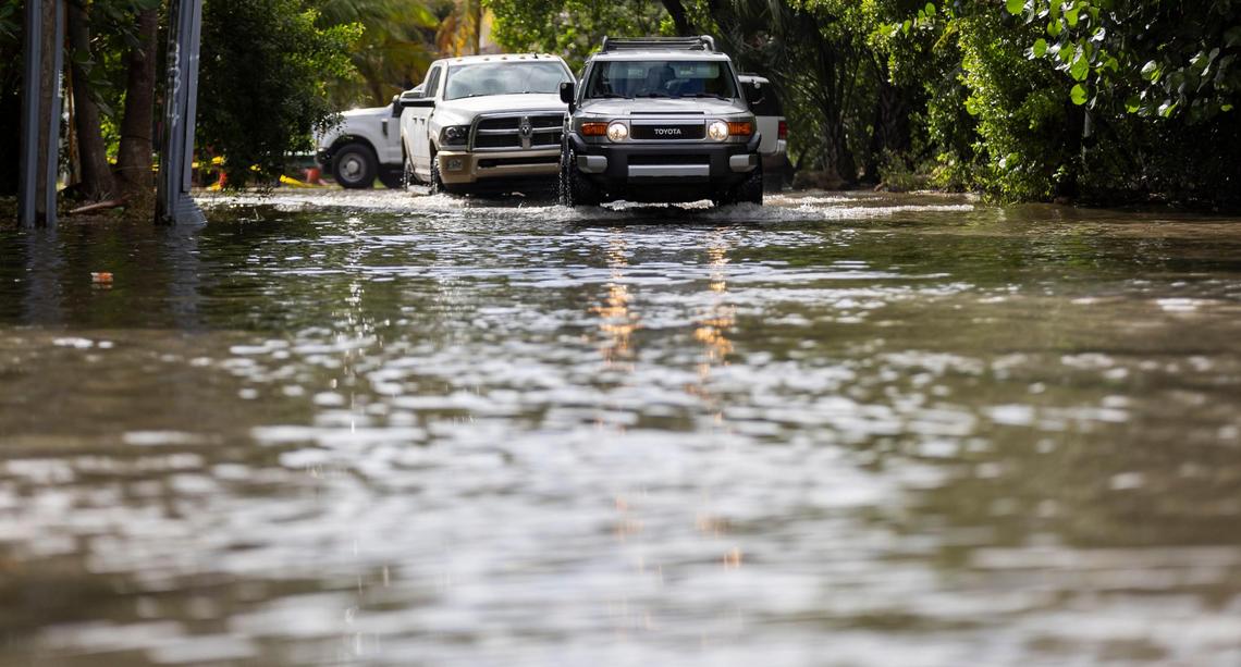 Vehicles make their way down a flooded street near Little River Pocket Park on Monday, Oct. 30, 2023 in Miami, Fla. Monday was the highest king tide of the year for South Florida, flooding streets, driveways and parks.