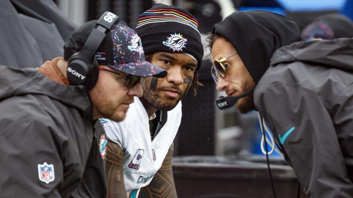 Miami Dolphins Head Coach Mike McDaniel, at right, talks with Miami Dolphins Quarterbacks / Pass Game Coordinator Darrell Bevell as quarterback Tua Tagovailoa (1) looks on late in the second half of an NFL football game against the Cleveland Browns at Huntington Bank Field in Cleveland, Ohio, on Sunday, October 19, 2025. 