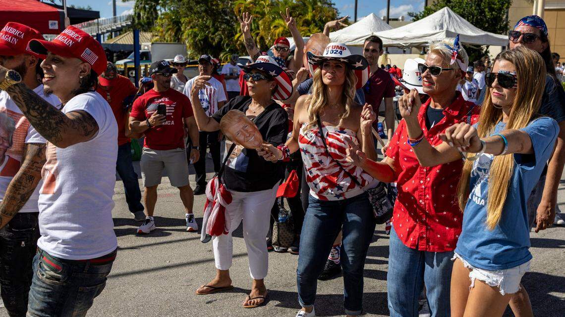 Trump supporters dance in the streets as they patiently wait in the hot sun to get into Ted Hendricks Stadium for the rally.