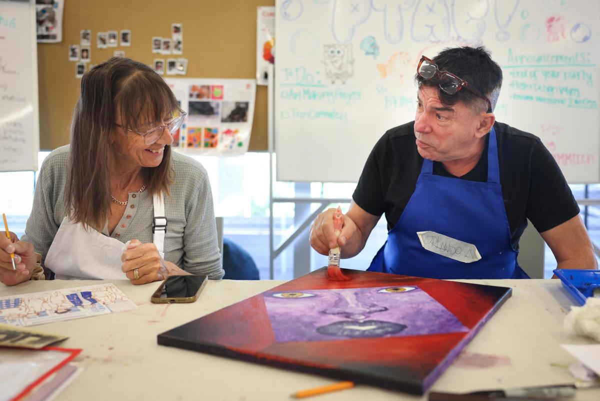 Mo Cooling, left, talks to Orlando Airas about his painting during open studio time in an art class for people over 55 years of age at Perez Art Museum Miami in downtown Miami.