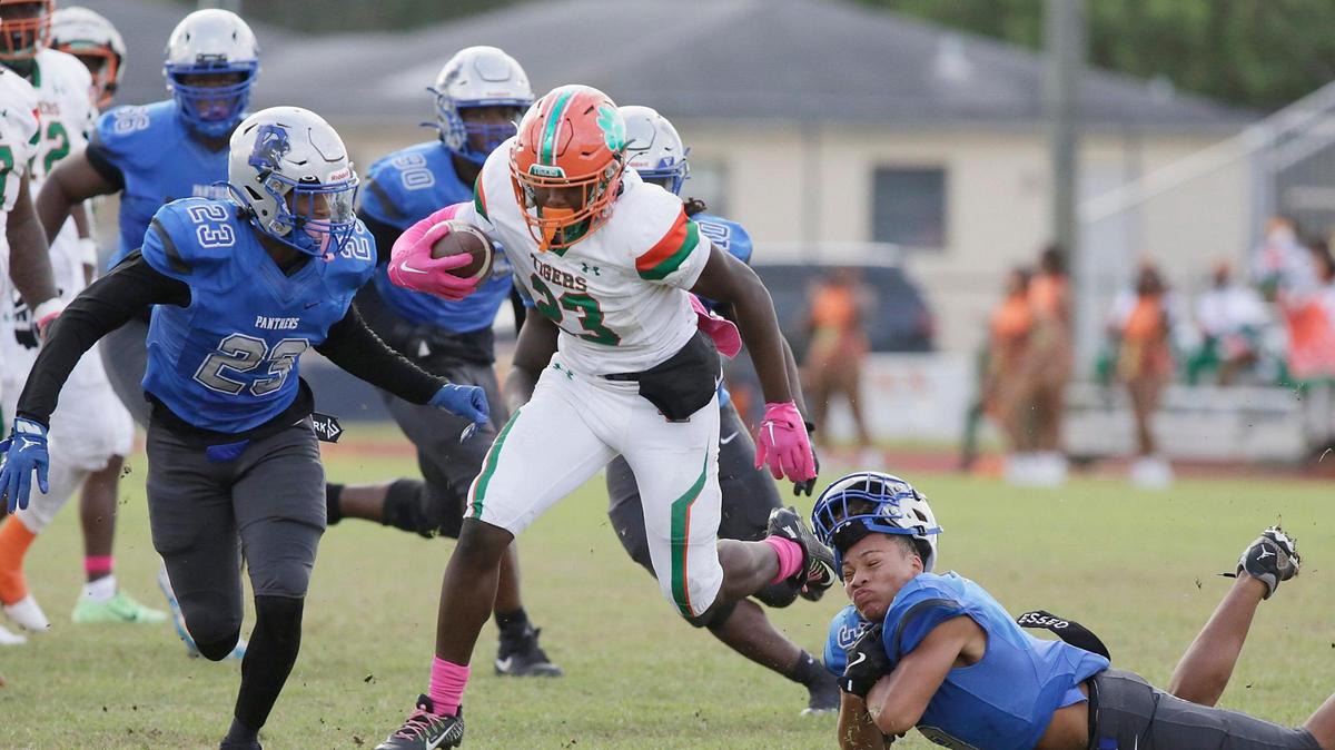 Blanche Ely Tigers running back Kenson Louis (23) attempt to break free from Dillard Panthers defenders during football game on Saturday, October 19, 2024 at Dillard HS in Fort Lauderdale. Andrew Uloza / for Miami Herald