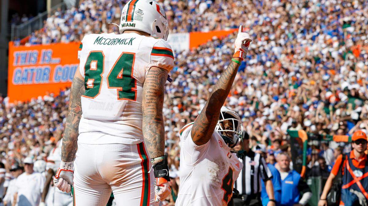 Miami Hurricanes running back Mark Fletcher Jr. (4) celebrates with teammate McCormick (84) after scoring a touchdown during the second half of an NCAA college football game against the Florida Gators at Ben Hill Griffin Stadium in Gainesville, Florida, on Saturday, August 31, 2024.