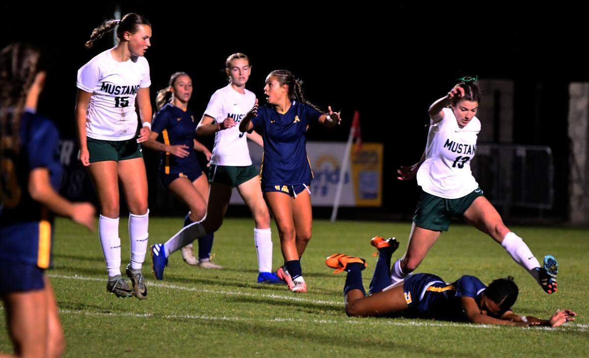 St. Thomas Aquinas sophomore Sophie Barnes smothers the ball under her body while Lakewood Ranch midfielder Isla Stewart (13) leaps over her during the first half of a Class 6A state semifinal against Lakewood Ranch at Lake Myrtle Sports Complex on Thursday.