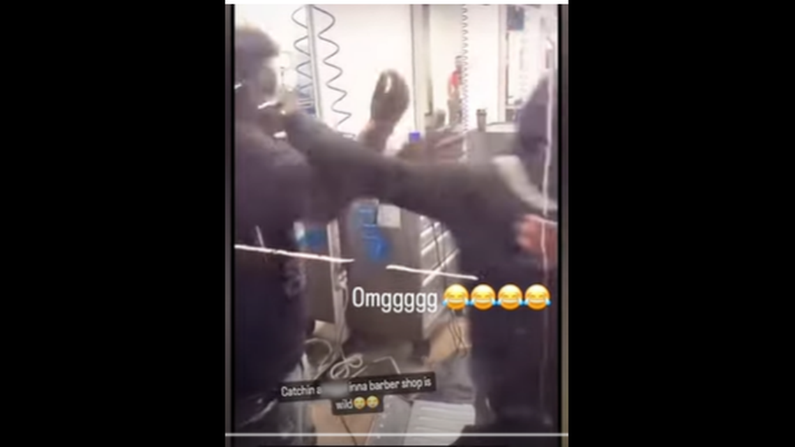 A juvenile (left) was attacked by a group of people in a barber shop and thrown through a window, video shows.