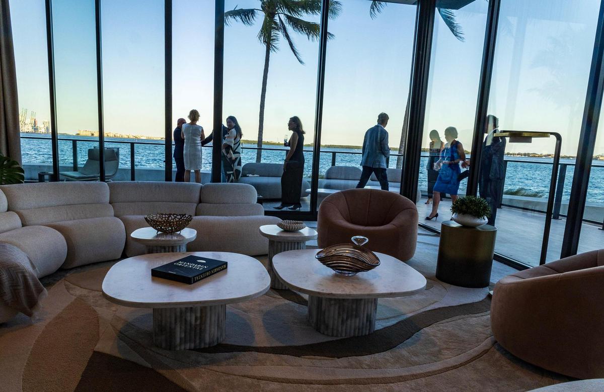 Partygoers check the model of living room and the terrace of an apartment at the Mandarin Residences sales center on Thursday May 15, 2025.