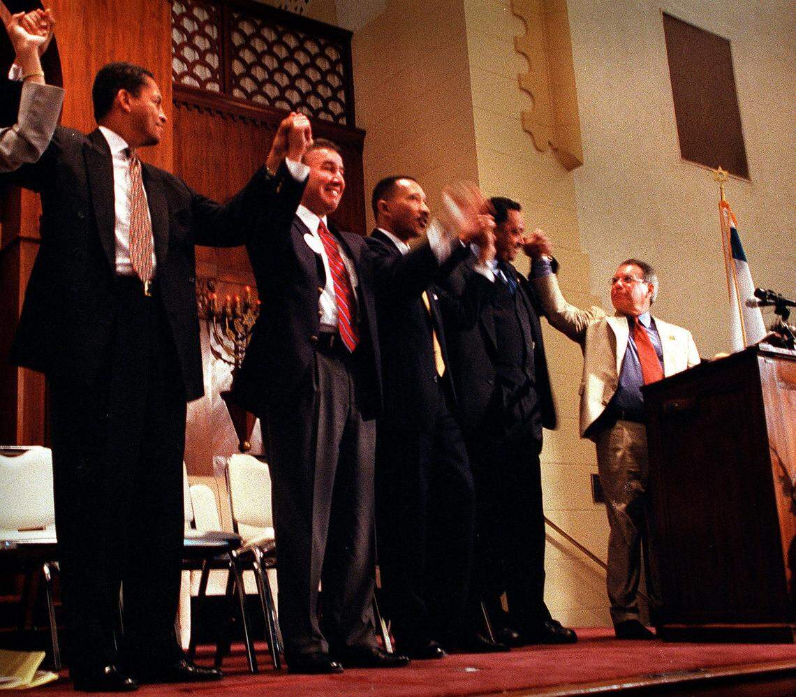 In 2000, at the Public Forum on Florida Vote at Temple Isreal of Greater Miami, Daryl Jones; Ralph Neas, president fo People for the American Way (left); Kweisi Mfume, president of the NAACP; the Rev. Jesse Jackson, and Rabbi Steven Jacobs join hands.